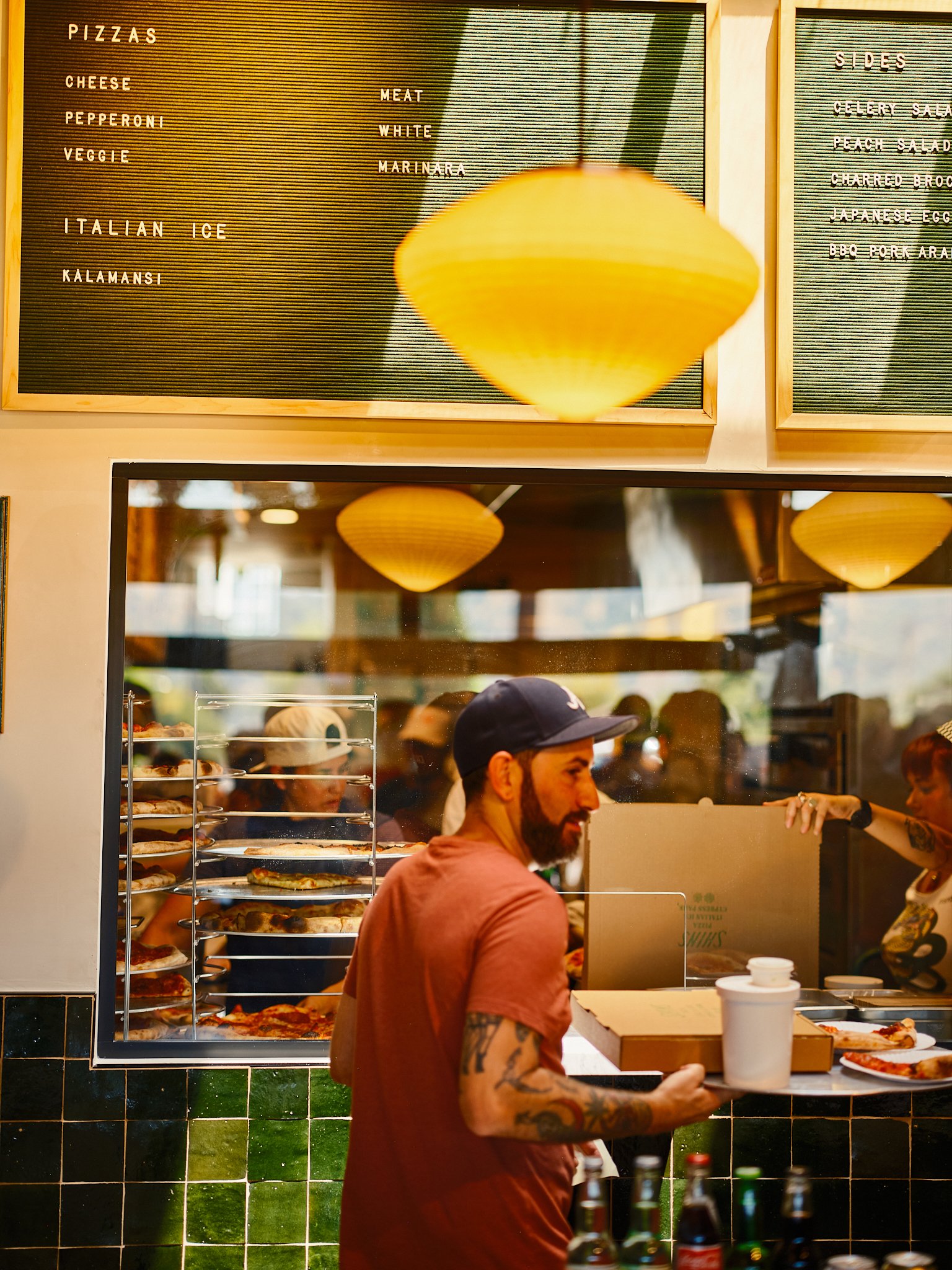 Interior of Shins Pizza, staff making pizza
